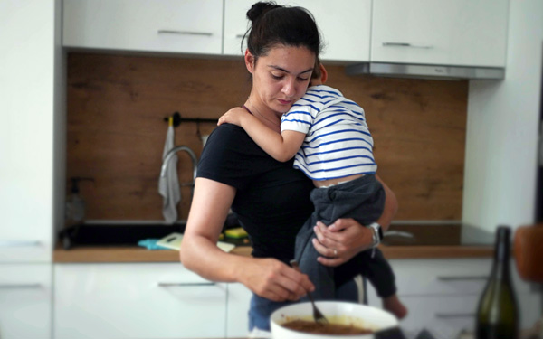    Mother and young child cooking in the kitchen together.